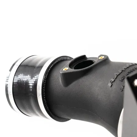 Vue détaillée du kit d'admission RamAir Proram pour la Toyota GR Yaris. Le kit se compose d'un tuyau d'admission noir avec des colliers argentés et d'un raccord. On aperçoit un fond blanc neutre à l'arrière-plan.