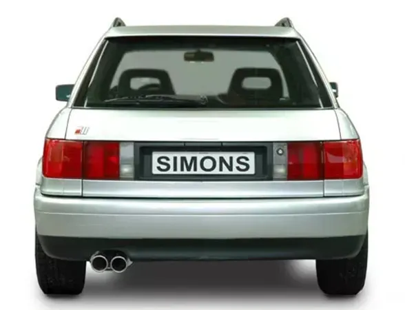 Vue arrière d'une Audi S2 Avant/combi argentée (B4) avec feux arrière, lunette arrière et pare-chocs. Plaque d'immatriculation "SIMONS" montée. A gauche, on voit un échappement sport à double tube du système d'échappement sport en acier inoxydable.
